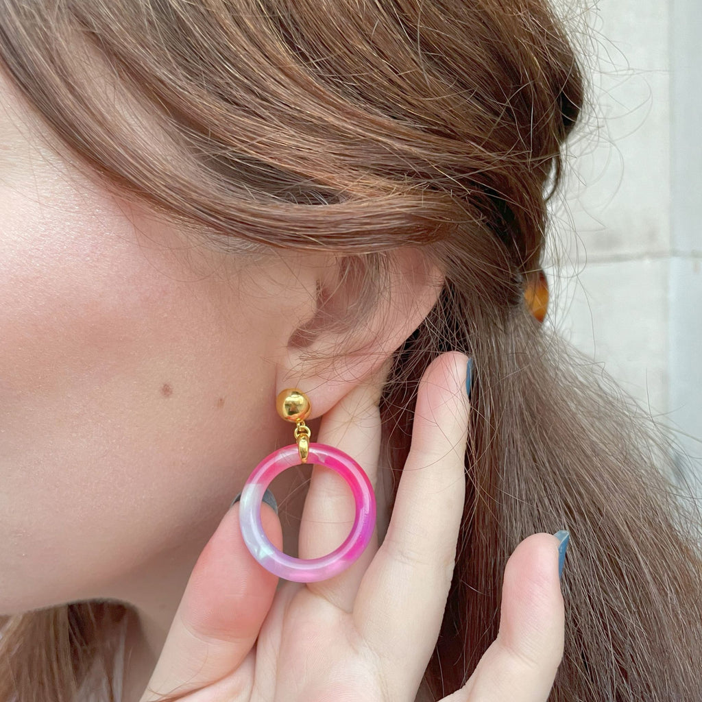 Close up of and ear and purple tortoiseshell earrings from the Audrey collection by Misia Mae. 