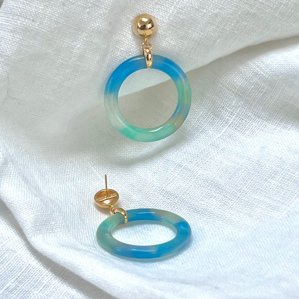 Blue earrings tortoiseshell hoop earrings from the Audrey collection by Misia Mae on a white linen fabric