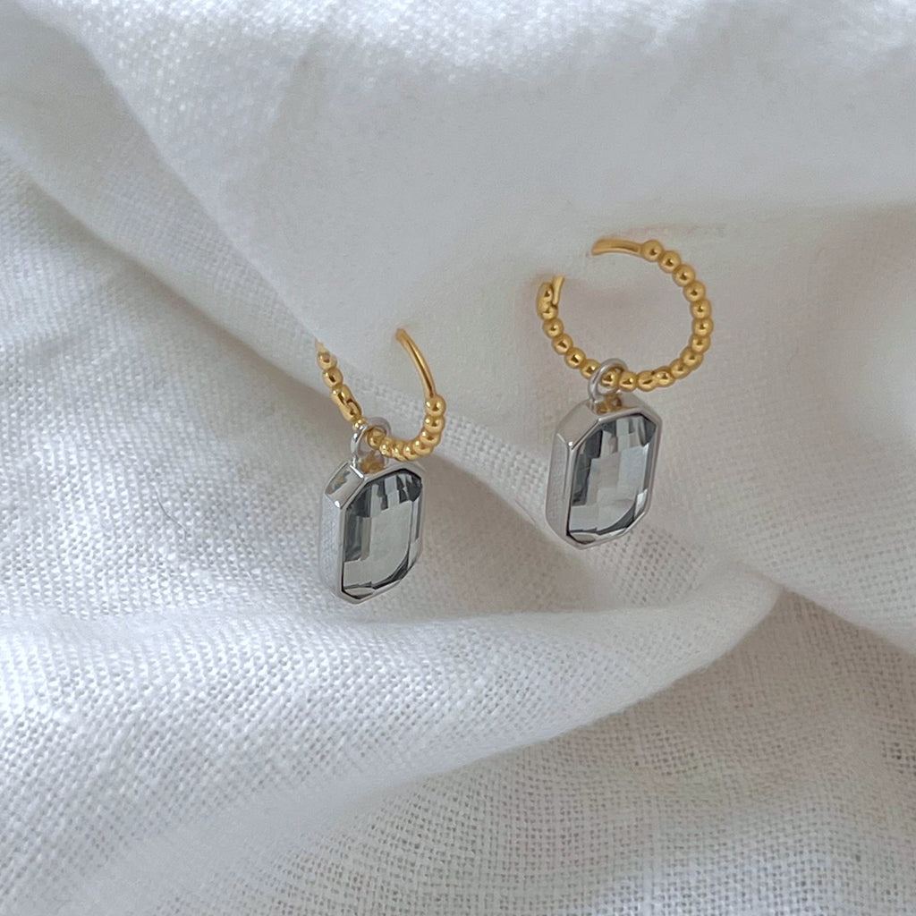 Mixed metal earrings side view on a white linen background, earrings by Misia Mae