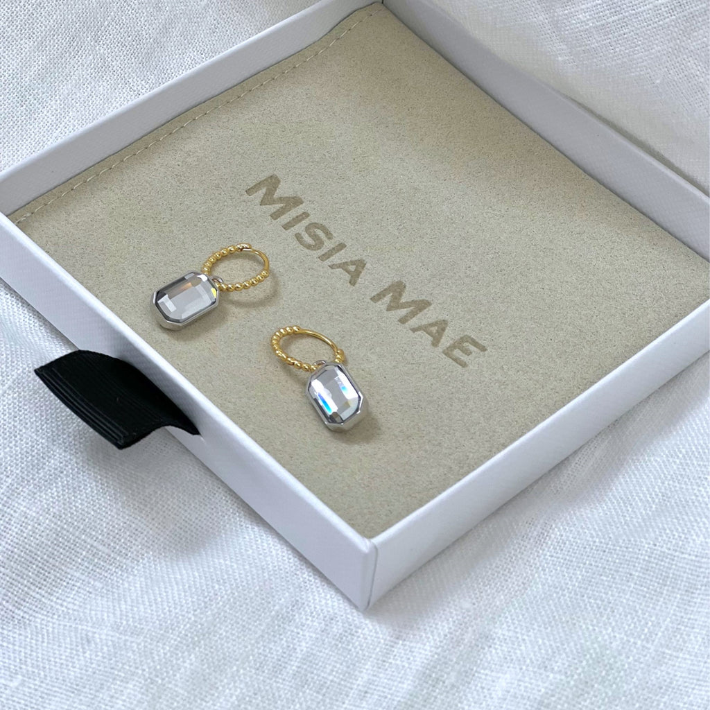 Mixed metal earrings in the Misia Mae jewellery box on a white linen background