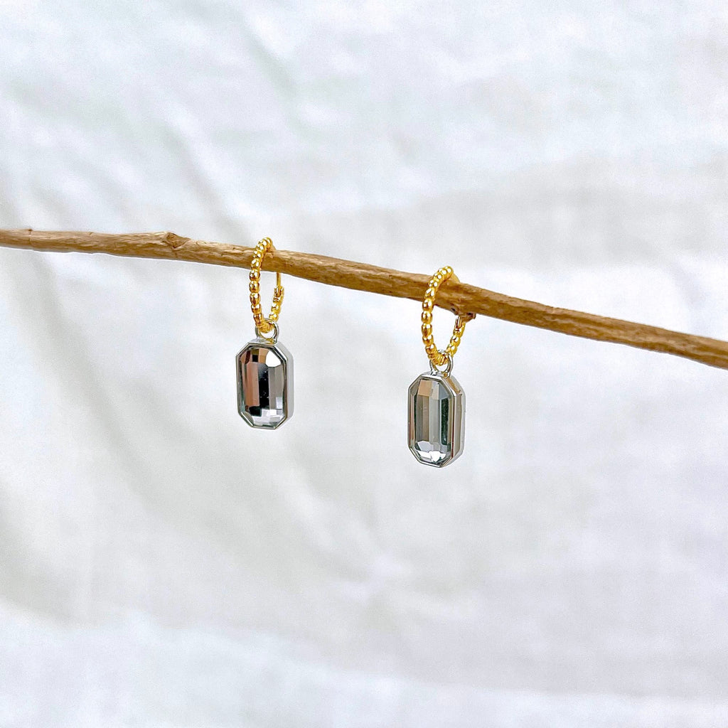 Mixed metal earrings by Misia Mae. The earrings are shown on a white linen background.