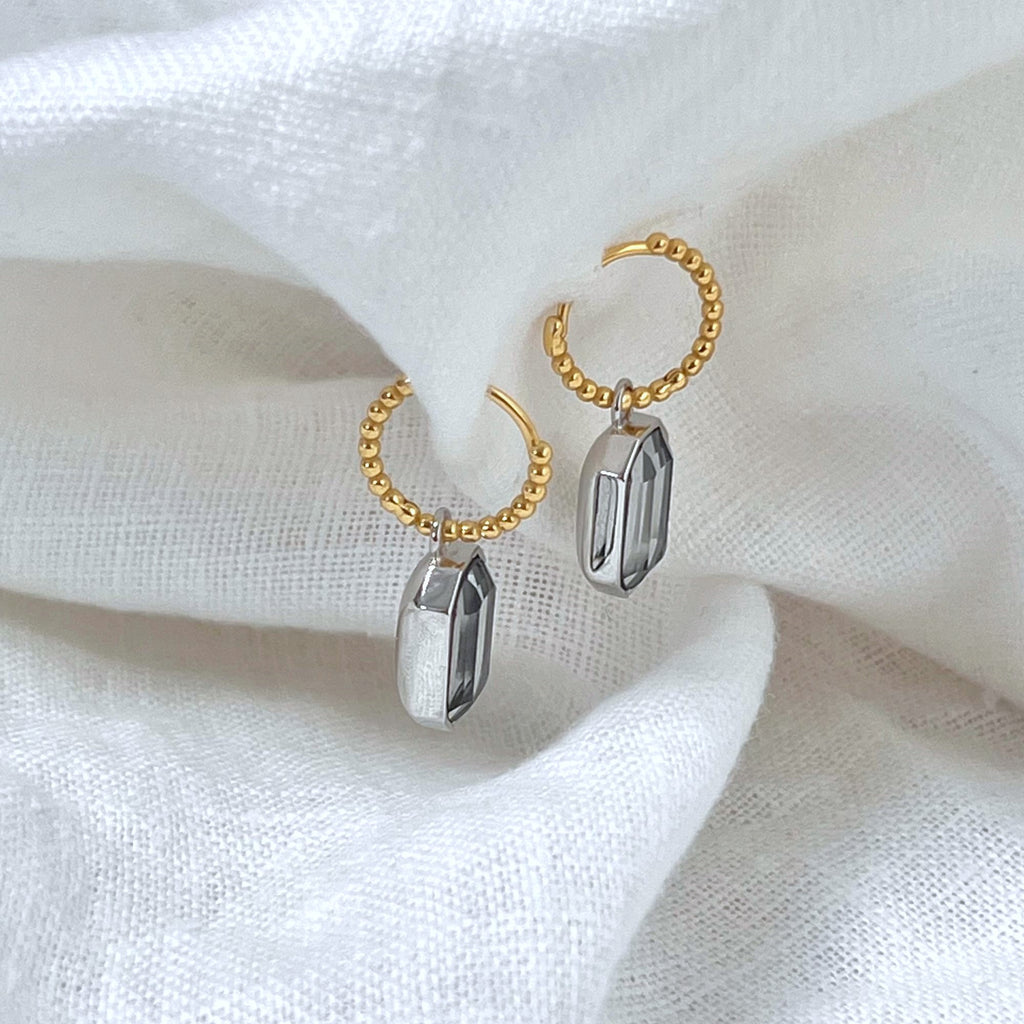 Mixed metal earrings on a white linen background, earrings by Misia Mae