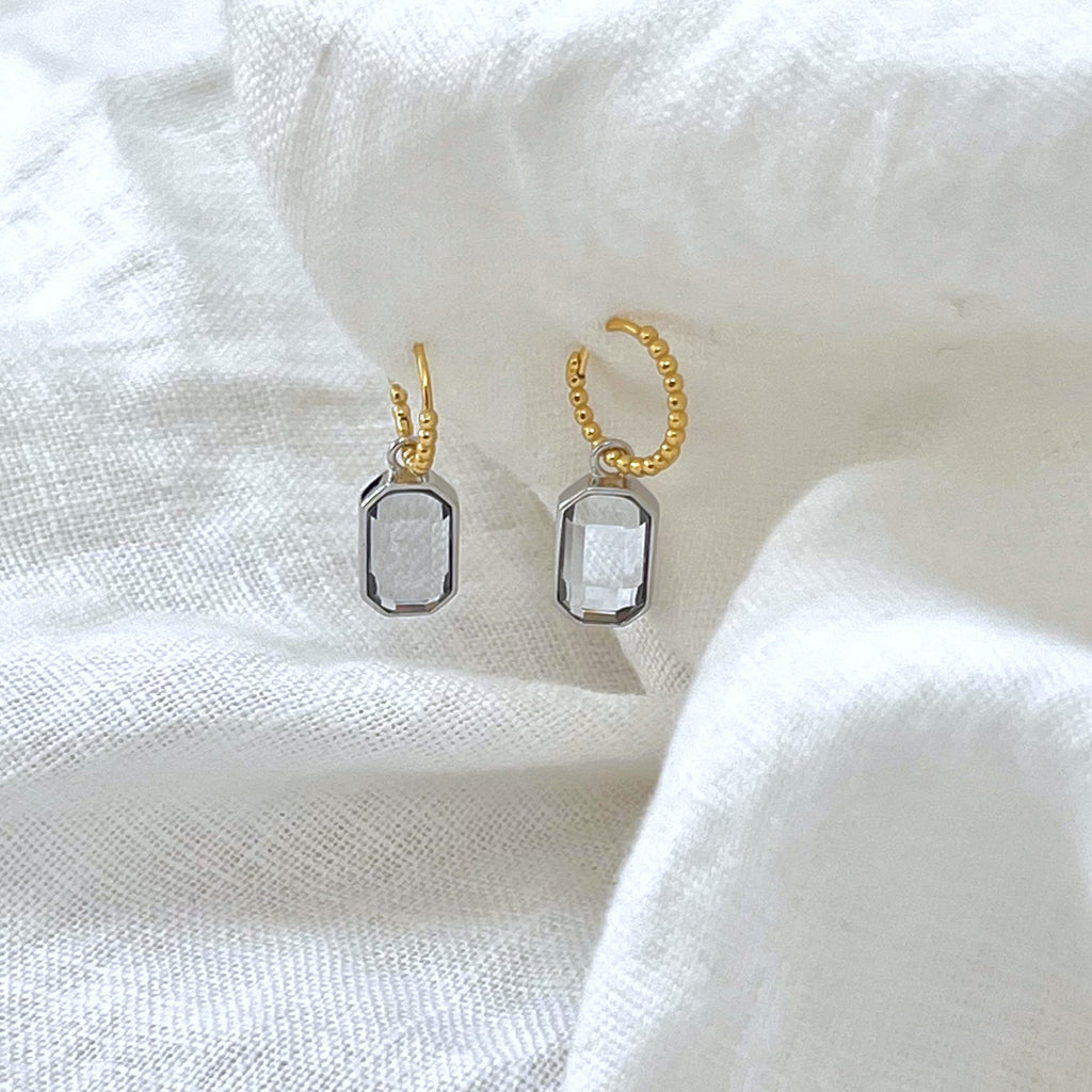 Mixed metal earrings on a white linen background, earrings by Misia Mae