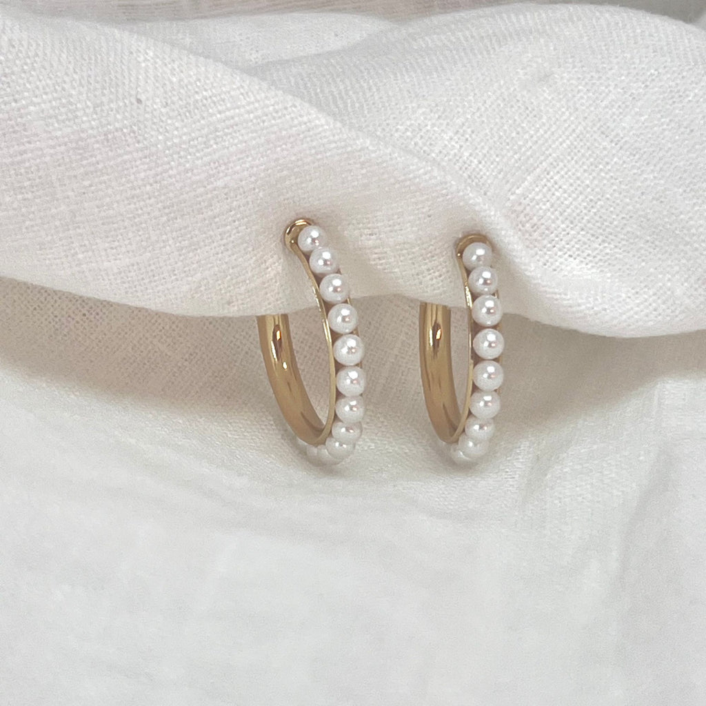 pearl hoop earrings on a white linen cloth
