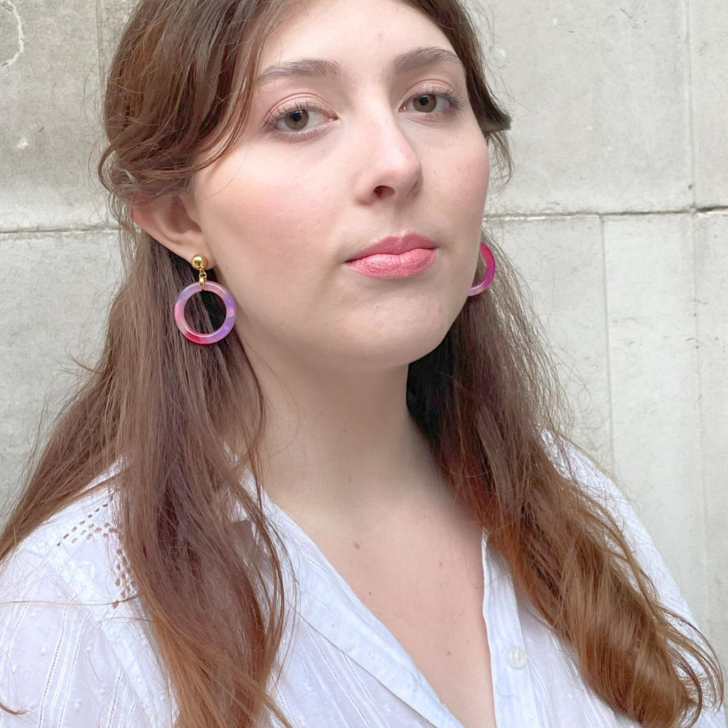 a light brown hair woman wearing purple and pink tortoiseshell earrings from the Audrey collection by Misia Mae