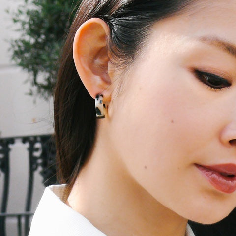 A brunette woman wearing tortoiseshell earrings blonde from the Olivia collection by Misia Mae