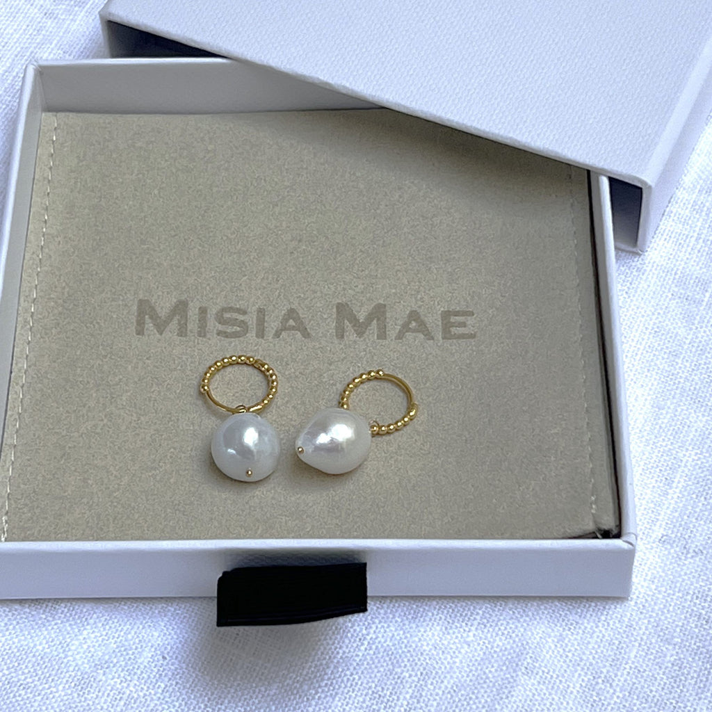 baroque pearl beaded gold huggies earrings in a Misia Mae jewellery box on a white linen background. Earrings by Misia Mae