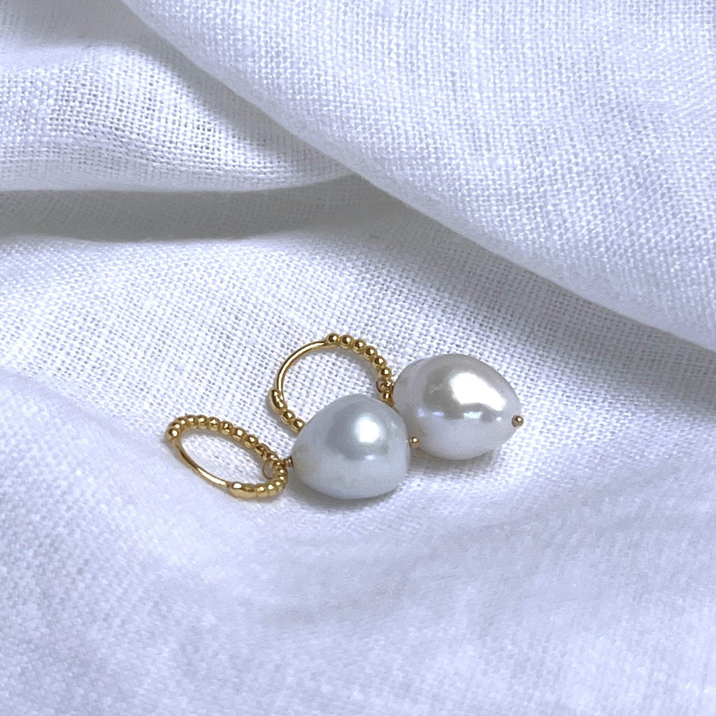 baroque pearl beaded gold huggies earrings on a white linen background - side view. Earrings by Misia Mae