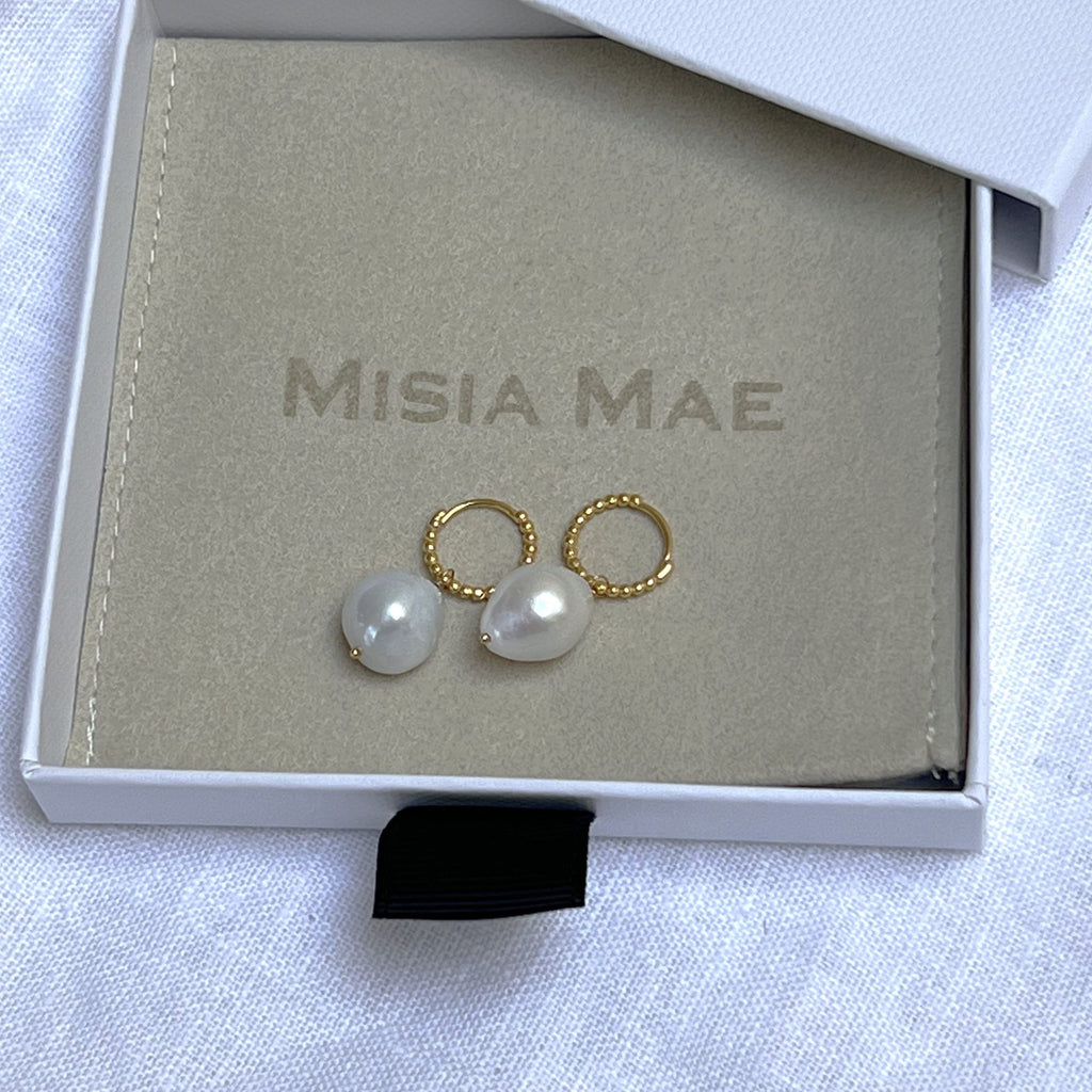 baroque pearl beaded gold huggies earrings in a Misia Mae jewellery box on a white linen background. Earrings by Misia Mae