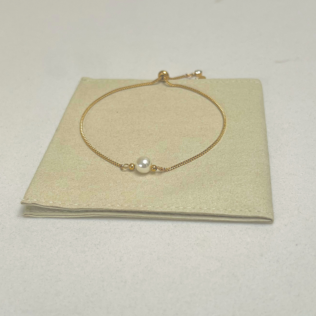 gold plated slider bracelet with pearl on a pouch