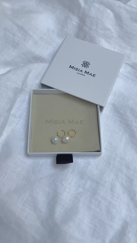 baroque pearl beaded gold huggies earrings in a Misia Mae jewellery box on a white linen background. Earrings by Misia Mae