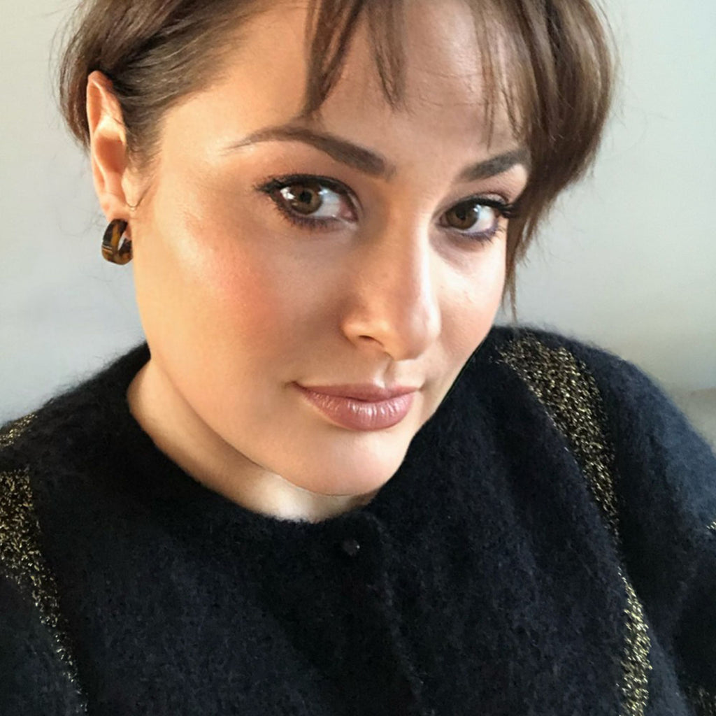 a brunette women wearing a black and gold retro jumper and tortoiseshell hoops brunette from Misia Mae