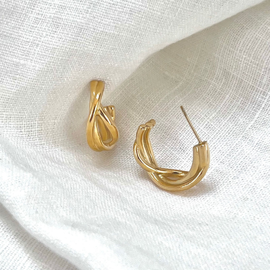 Twisted hoop earring from the Amelia collection by Misia Mae. The earrings are on a white linen fabric