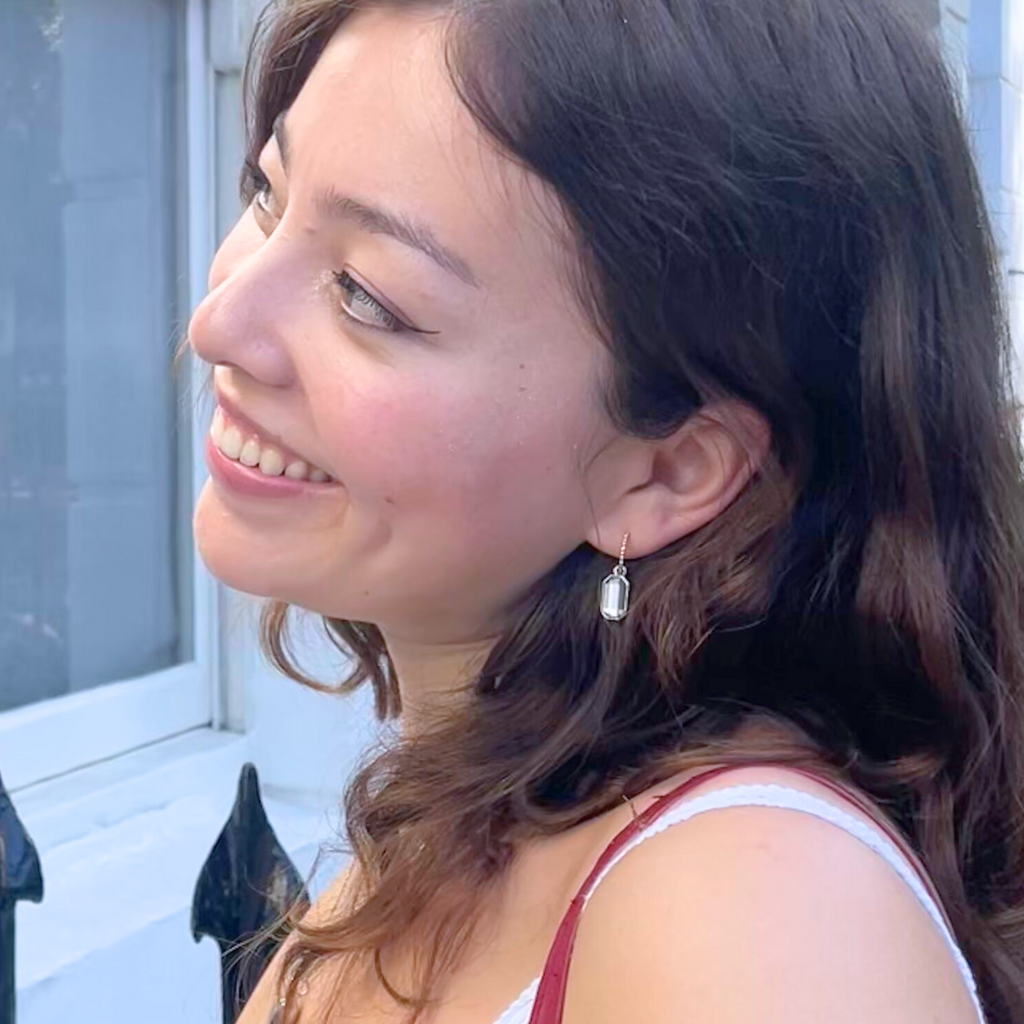 A brunette woman wearing mixed metal earrings 