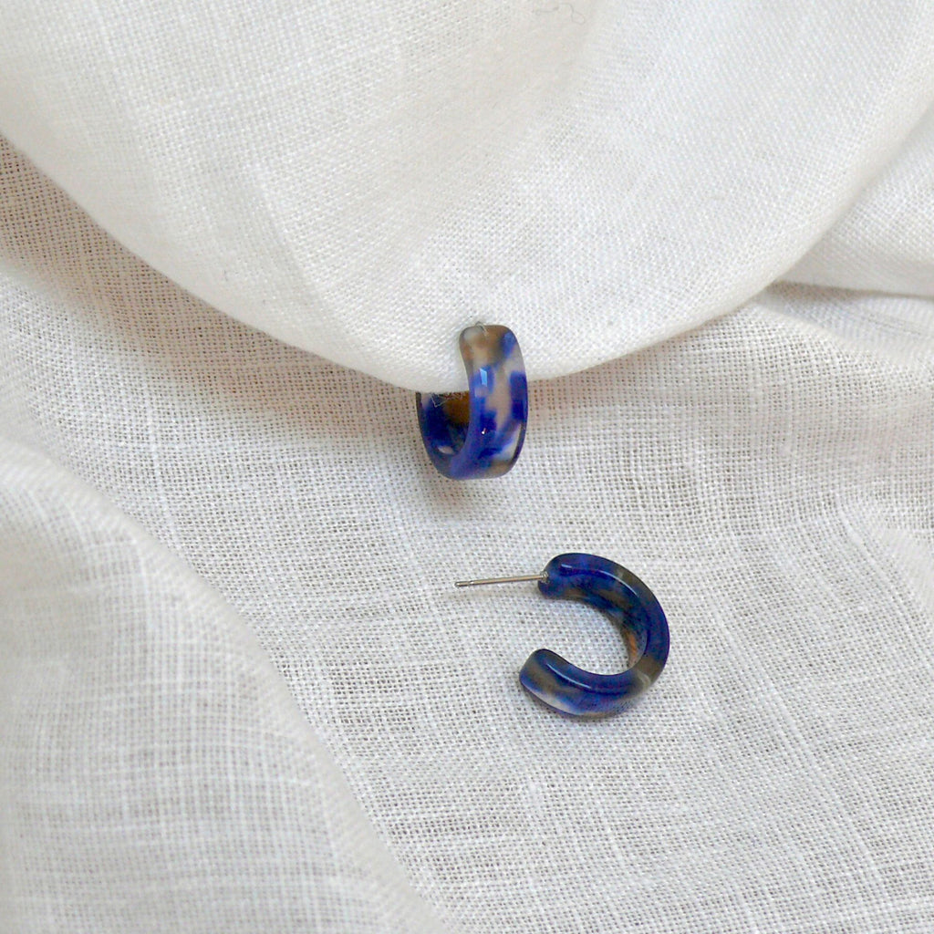 Tortoiseshell earrings blue from the Olivia collection by Misia Mae on a white linen fabric